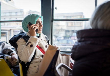 Muslim woman riding public transport in cityの写真素材