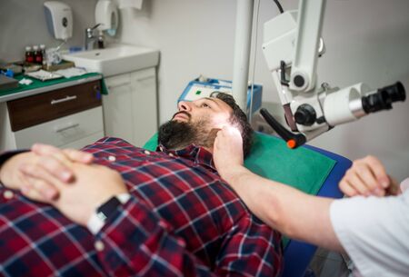 Doctor in hospital checking patient earの写真素材
