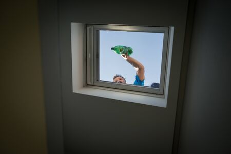 Man on loft window cleaningの写真素材