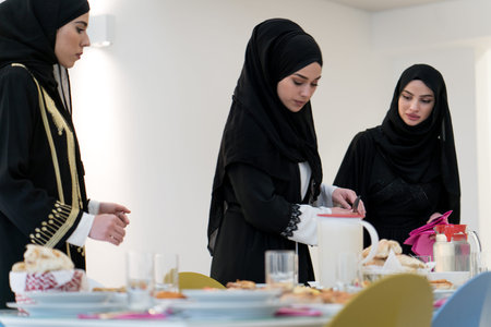 Muslim girls preparing table for family meal