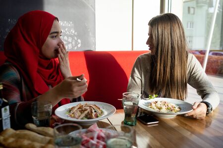 Female friends having lunch together in restaurantの写真素材