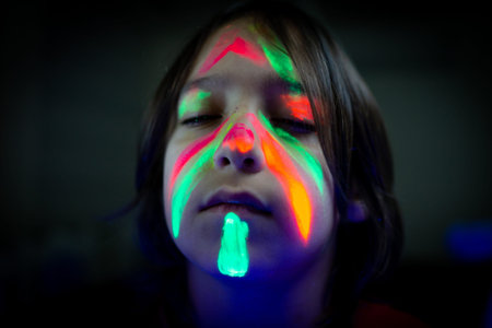 Little boy with fluorescent paint glowing portrait