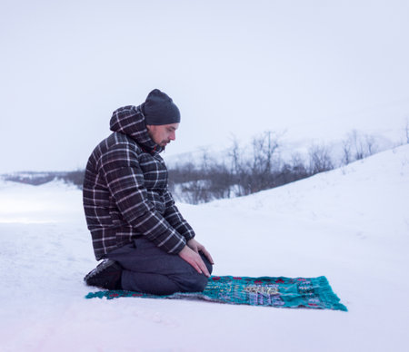 Muslim traveler praying in winter mountain , high qualityの写真素材