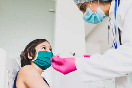 Little cute child with mask getting injectionの写真素材