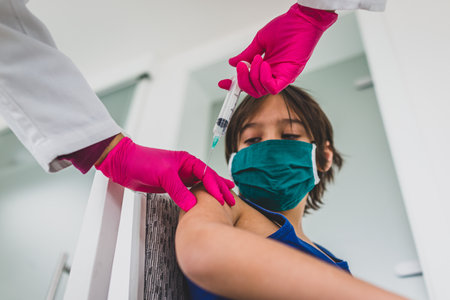 Little cute child with mask getting injectionの写真素材