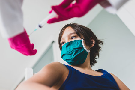 Little cute child with mask getting injectionの写真素材