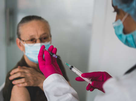 Senior old woman in hospital getting vaccine 2021の写真素材