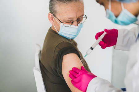 Senior old woman in hospital getting vaccine 2021の写真素材