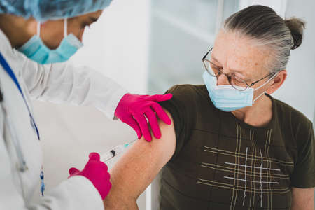 Senior old woman in hospital getting vaccine 2021の写真素材