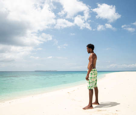 Young black African man on beautiful beach seaの写真素材
