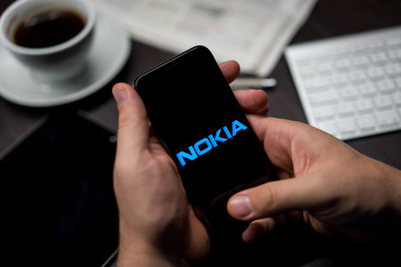 New York, New York / USA - 11 11 2019: Logo of Nokia on the iPhone X in hands in officeのeditorial素材