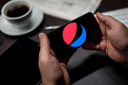 New York, New York / USA - 11 11 2019: Logo of Pepsi on the iPhone X in hands in officeのeditorial素材