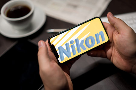 New York, New York / USA - 11 11 2019: Logo of Nikon on the iPhone X in hands in officeのeditorial素材