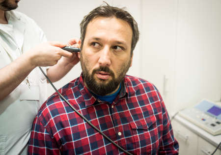 Doctor in hospital checking patient the earの写真素材