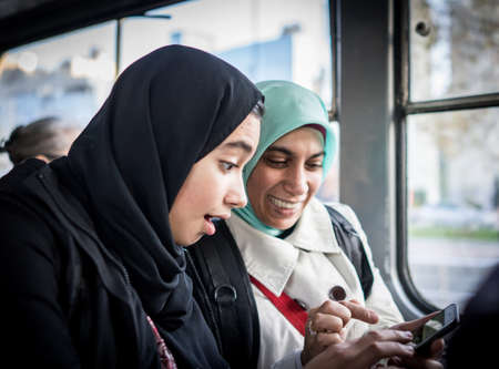 Mother and daughter riding public transport in the cityの写真素材