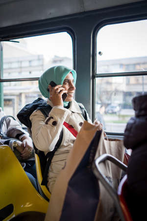Muslim woman riding public transport in the cityの写真素材