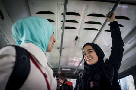 Mother and daughter riding public transport in the cityの写真素材