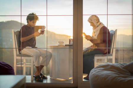Mother and son enjoying drinking tea on the balconyの写真素材