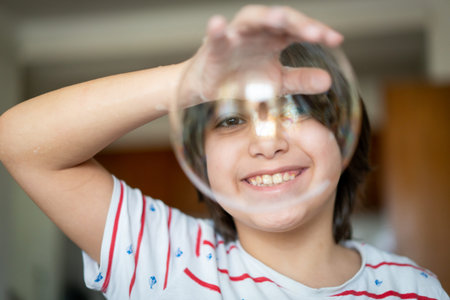 Little creative kid having fun with soap bubble in lockdown