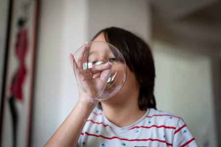 Little creative kid having fun with soap bubble in lockdown