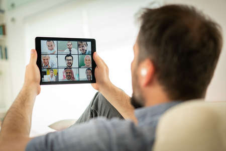 Mid adult man having online conference working at homeの写真素材