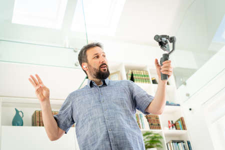 Adult male vlogger streaming online at homeの写真素材