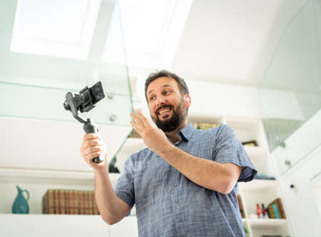 Adult male vlogger streaming online at homeの写真素材