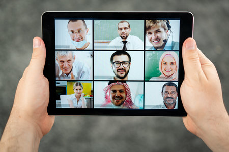 Online business conference screen in hands new normalの写真素材