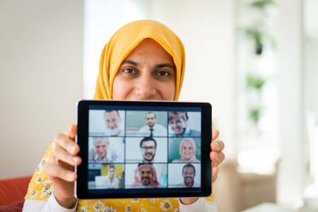 Muslim womah holding tablet with conference screenの写真素材