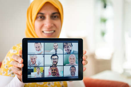 Muslim womah holding tablet with conference screenの写真素材