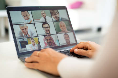 Online business conference screen in hands new normalの写真素材