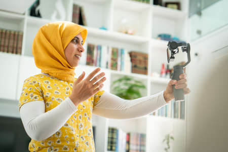 Muslim woman streaming video content online at homeの写真素材
