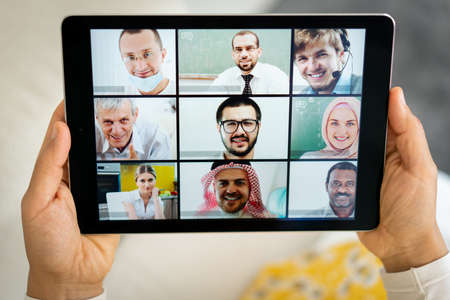 Online business conference screen in hands new normalの写真素材