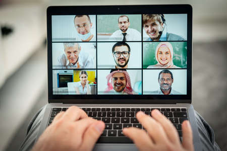 Online business conference screen in hands new normalの写真素材