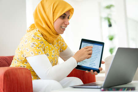 Muslim woman teaching on tablet at home todayの写真素材