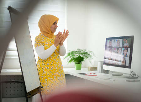 Arabic female teacher working with children online school during pandemicの写真素材