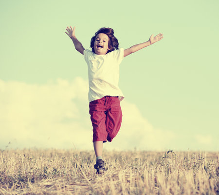 Happiness and freedom. Kid standing in nature with large copy spaceの写真素材