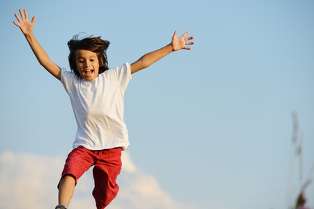 Happy kid running on beautiful fieldの写真素材