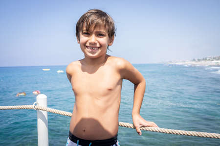 Little cute boy on sea pier enjoying vacationの写真素材