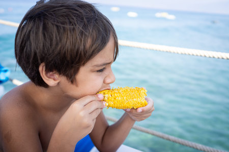 Boy sitting on beach pier and eating