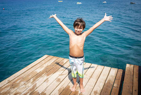 Little cute boy on sea pier enjoying vacationの写真素材