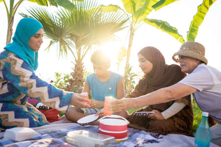 Happy family enjoying picnic on beach near seaの写真素材