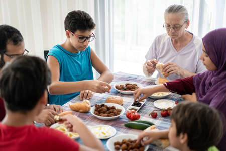 Happy family enjoying eating food in dining roomの写真素材