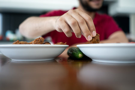 Arabic boy eating home made falafel indoorsの写真素材