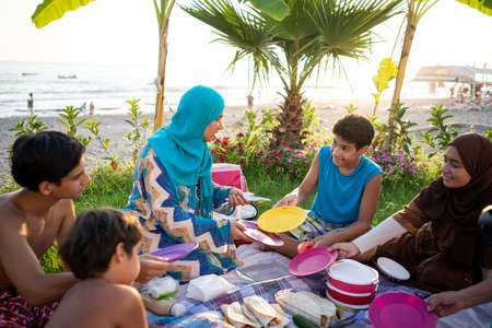 Happy family enjoying picnic on beach near seaの写真素材