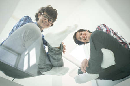 Low angle of father and sons sitting on glassの写真素材