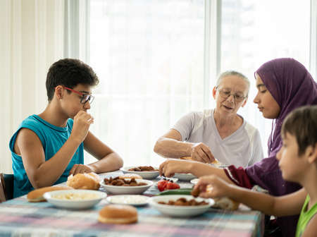 Happy family enjoying eating food in dining roomの写真素材