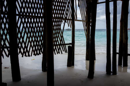Wooden pillars on ocean shore into blue water with no peopleの写真素材