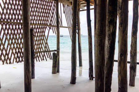 Wooden pillars on ocean shore into blue water with no peopleの写真素材