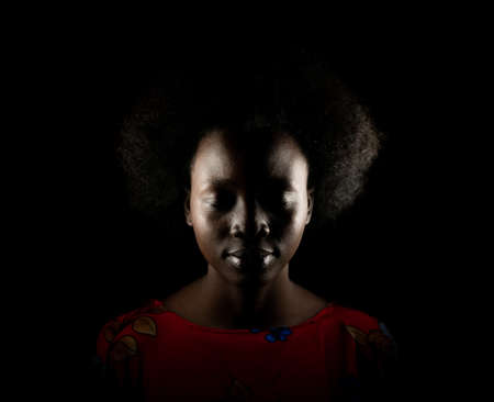 Dark portrait of young black woman in studioの写真素材